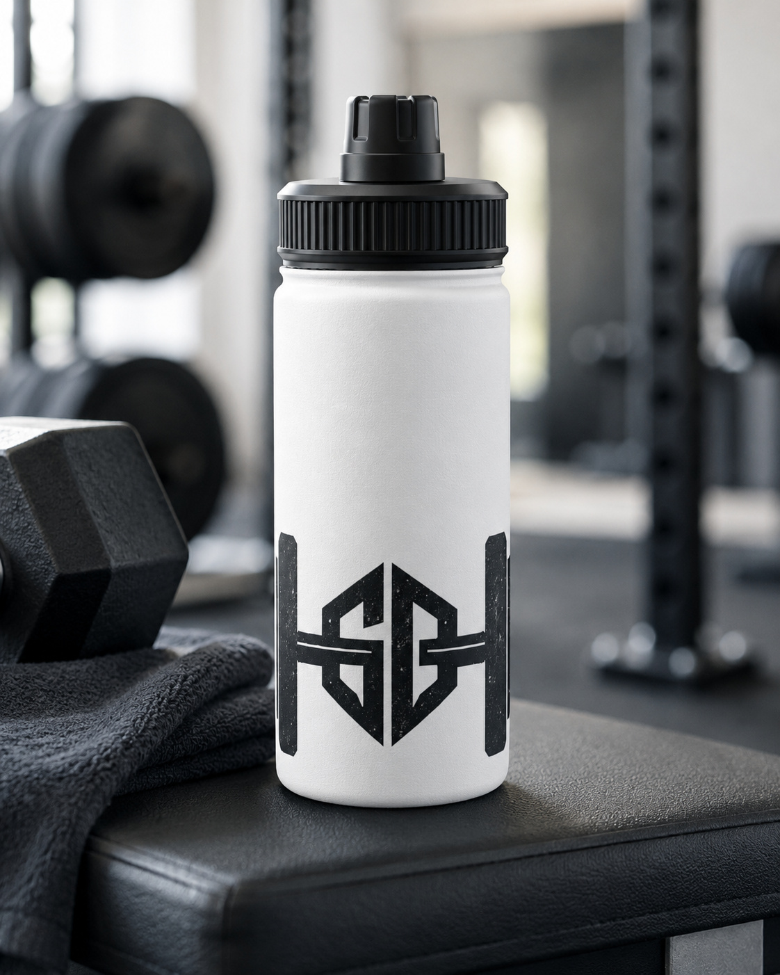 White gym water bottle with black barbell logo on a weight bench beside a dumbbell